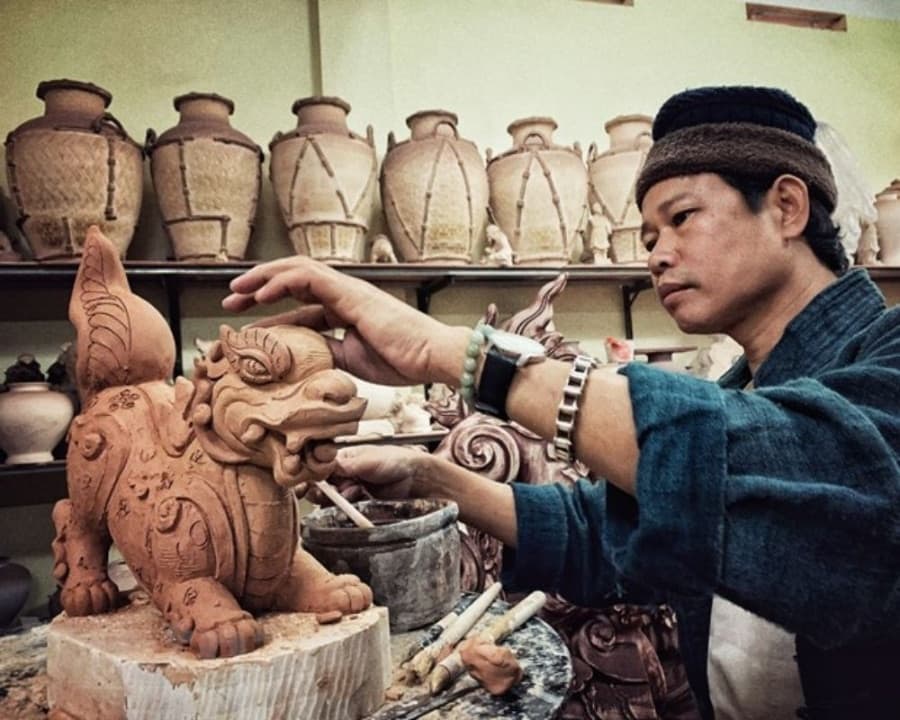 An artisan shaping clay on a pottery wheel in their studio